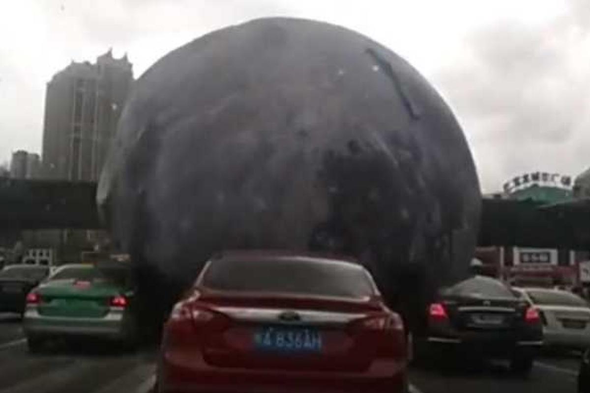 В Китае огромный "лунный" шар развеселил водителей, прокатившись по крышам авто В Китае огромный "лунный" шар развеселил водителей, прокатившись по крышам авто
