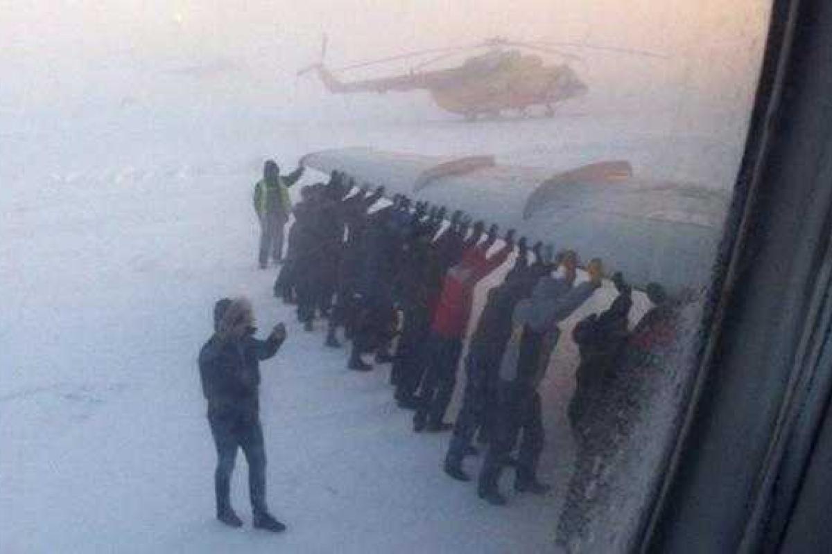 В Красноярском крае пассажиры толкали примерзший самолет в 52-градусный мороз В Красноярском крае пассажиры толкали примерзший самолет в 52-градусный мороз