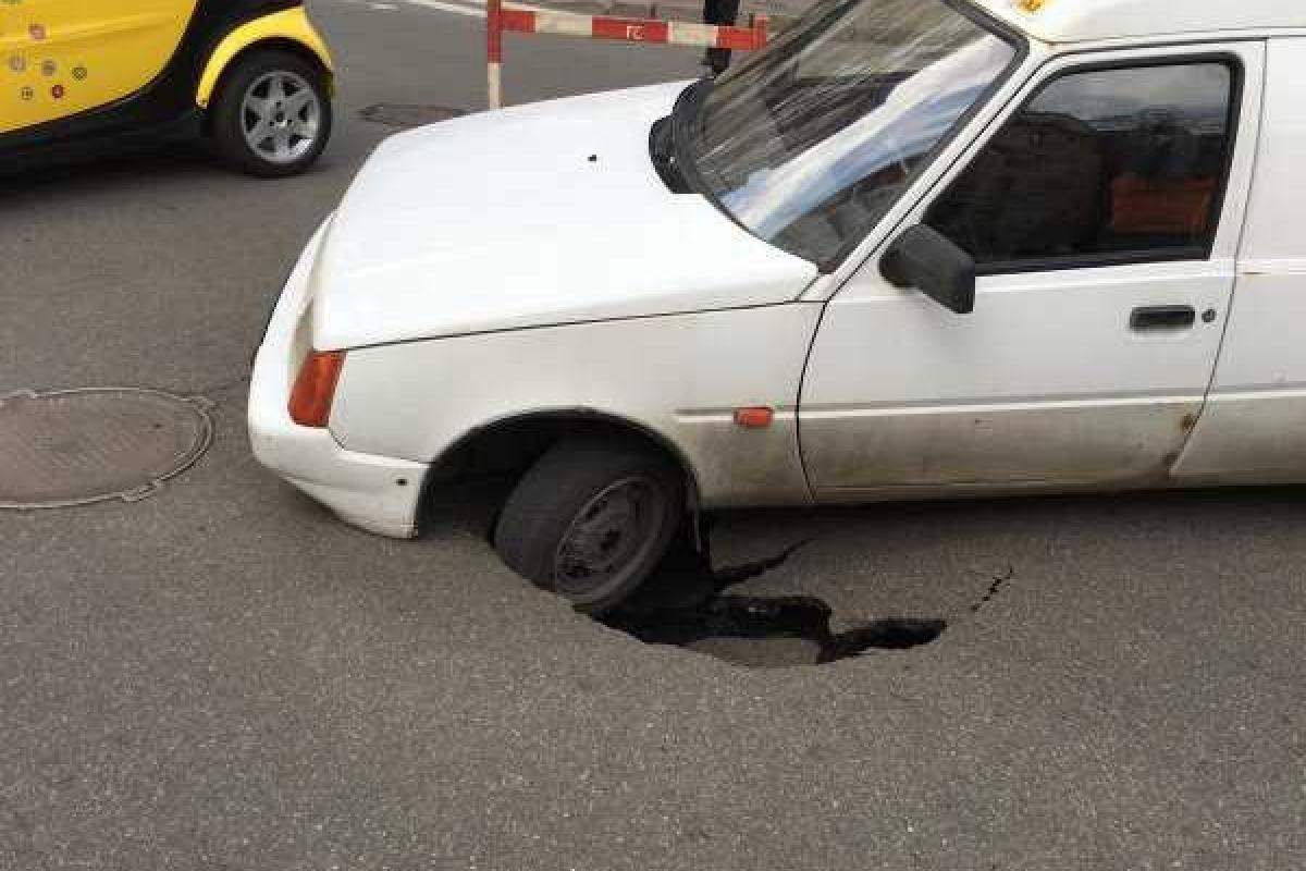 В центре Киева провалился асфальт: авто оказалось в ловушке В центре Киева провалился асфальт: авто оказалось в ловушке
