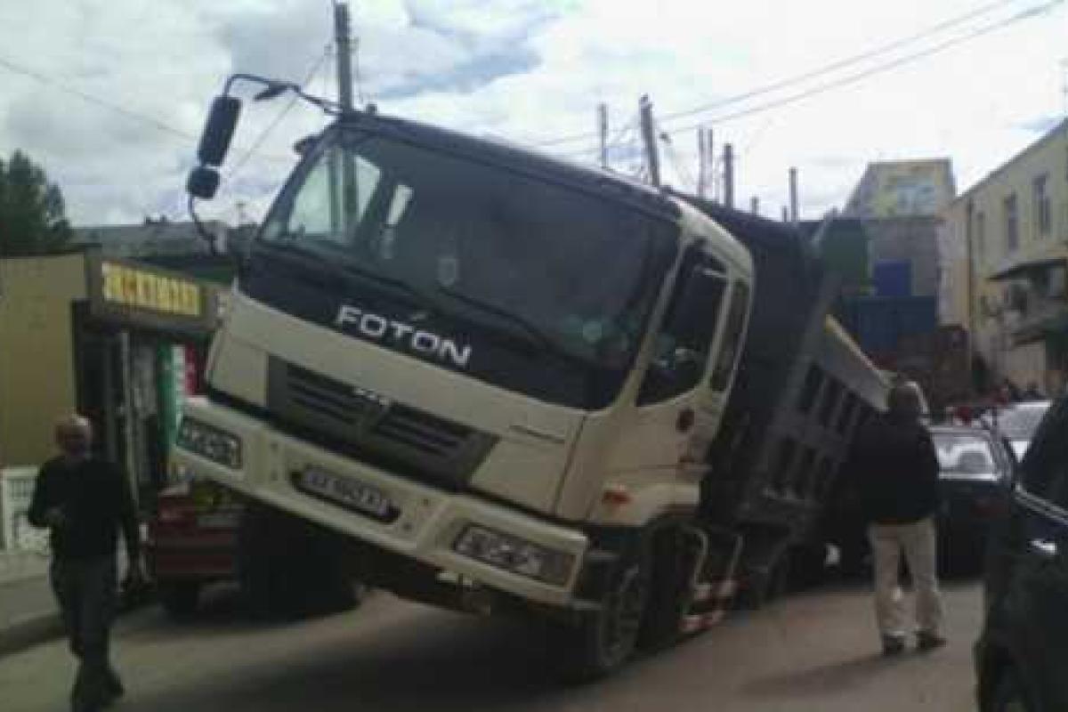 В Харькове грузовик провалился под асфальт, придавив легковушку В Харькове грузовик провалился под асфальт, придавив легковушку
