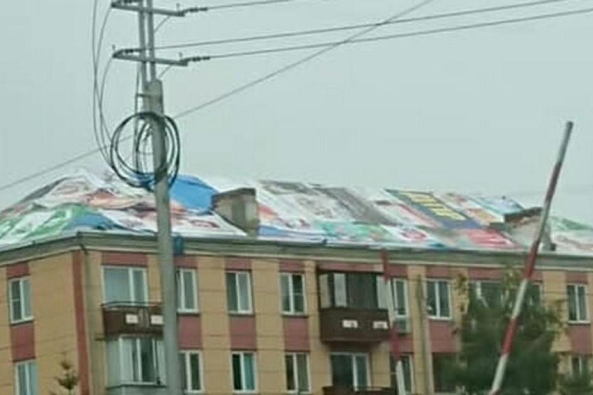 Вся суть в одном фото: В России дырявую крышу пятиэтажки залатали предвыборными баннерами