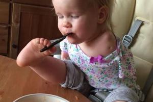 До слёз: Безрукая маленькая девочка научилась есть ногами