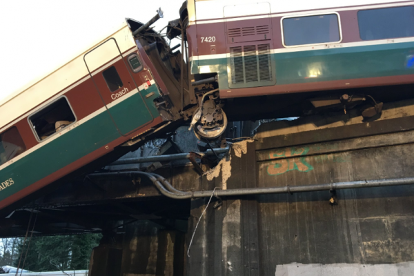 В США пассажирский поезд рухнул с моста на дорогу